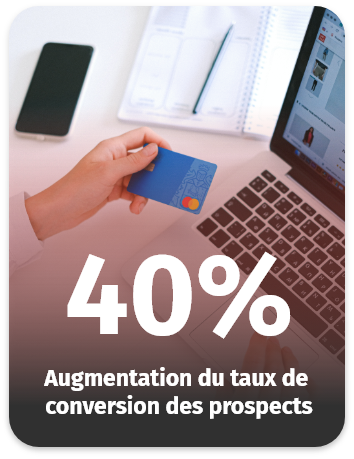 Personne tenant une carte bancaire devant un ordinateur, représentant une augmentation de 40 % du taux de conversion des prospects.