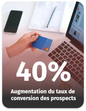 Personne tenant une carte bancaire devant un ordinateur, représentant une augmentation de 40 % du taux de conversion des prospects.